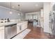 Open concept kitchen featuring stainless steel appliances, granite countertops, breakfast bar, and hardwood floors at 11062 Discovery Nw Dr, Concord, NC 28027