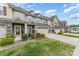 View of townhomes with two-car garages, stone accents, and well-manicured lawns on a sunny day at 11062 Discovery Nw Dr, Concord, NC 28027