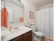 Bathroom with white shower curtain, dark vanity with a white counter, toilet and peach-colored decor at 118 Maplecrest Dr, Kings Mountain, NC 28086
