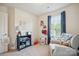 Bright bedroom with a crib, chair and sports-themed décor near a window with blue curtains at 118 Maplecrest Dr, Kings Mountain, NC 28086