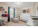 Bedroom with a white crib, accent sports-themed artwork, and a cozy white armchair at 118 Maplecrest Dr, Kings Mountain, NC 28086