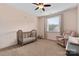 Bright Bedroom with a crib by the window, a soft armchair, and carpeted floors at 12604 Congregation Dr, Charlotte, NC 28278