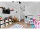 Open bedroom featuring wood floors, ceiling fan, smart TV, closet, and play kitchen at 12604 Congregation Dr, Charlotte, NC 28278