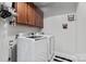 Convenient laundry room featuring a washer, dryer, storage, and a black-and-white patterned floor at 12604 Congregation Dr, Charlotte, NC 28278