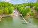 Stunning aerial view of lake house with private boat dock, surrounded by lush greenery at 131 High Lake Dr, Statesville, NC 28677