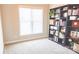 Bright bedroom with a large window, neutral walls, and a built-in bookcase for storage at 1424 South St, Cornelius, NC 28031