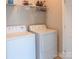 Functional laundry room featuring white appliances, ample shelving, and a clean, organized space at 1424 South St, Cornelius, NC 28031