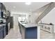 Beautiful kitchen boasts navy cabinets, granite counters, stainless appliances, large island and stairs to the second floor at 147 Morning Gap Pkwy, Fort Mill, SC 29715