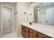 Neutral bathroom features a wood vanity with black fixtures, a large mirror, and a shower at 15535 Eagleview Dr, Charlotte, NC 28278