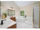 A light-filled bathroom with dual sinks, a soaking tub, and a separate shower, creating a spa-like retreat at 15535 Eagleview Dr, Charlotte, NC 28278