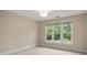 A bright bedroom featuring three large windows, neutral tones, and carpeted floors at 15535 Eagleview Dr, Charlotte, NC 28278