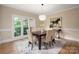 Dining room features hardwood floors, neutral paint, a wood table, seating for six, and natural light at 15535 Eagleview Dr, Charlotte, NC 28278