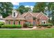 Well maintained brick two-story home featuring manicured lawn and mature trees under a cloudy sky at 15535 Eagleview Dr, Charlotte, NC 28278