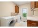Functional laundry room equipped with a washer, a dryer, a sink, and ample counter space for folding clothes at 15535 Eagleview Dr, Charlotte, NC 28278