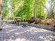 Outdoor brick patio features a seating area, fire pit, and lush landscaping, perfect for entertaining or relaxation at 166 Wilson Lake Rd, Mooresville, NC 28117