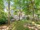 Serene backyard featuring a lush lawn, mature trees, and a charming patio area, ideal for relaxation at 166 Wilson Lake Rd, Mooresville, NC 28117