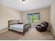 A comfy bedroom with a bed, plush recliner, and bright window at 166 Wilson Lake Rd, Mooresville, NC 28117