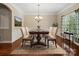 Formal dining room showcasing a wooden table with seating for six, complemented by a chandelier and natural light from a nearby window at 166 Wilson Lake Rd, Mooresville, NC 28117