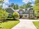 Charming two-story home with an inviting front yard, lush greenery, and a curved driveway at 166 Wilson Lake Rd, Mooresville, NC 28117