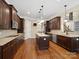 An open kitchen features dark wood cabinets, stainless steel appliances, and a granite island with pendant lighting at 166 Wilson Lake Rd, Mooresville, NC 28117