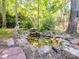 Backyard pond with waterfall feature is surrounded by lush greenery and trees at 166 Wilson Lake Rd, Mooresville, NC 28117