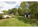 Landscaped backyard with a wooden fence, garden shed, and lush green lawn at 1965 Leesburg Dr, Clover, SC 29710