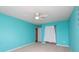 Bright bedroom features vibrant turquoise walls, neutral carpet, ceiling fan with light, and closet at 1965 Leesburg Dr, Clover, SC 29710