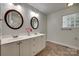 Well-lit bathroom featuring dual sinks, a vanity with storage, and decorative mirrors at 2150 Quiet Creek Pl, Rock Hill, SC 29732