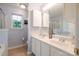 Bright bathroom featuring double sinks, vanity, a medicine cabinet, and window at 2416 Hart Rd, Charlotte, NC 28214