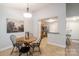 Cozy dining area with a round table, stylish black chairs, and view into the kitchen, adjacent to a painting at 2416 Hart Rd, Charlotte, NC 28214