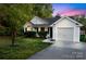 Charming one-story home featuring well-manicured landscaping and an attached garage, set against a colorful twilight sky at 2416 Hart Rd, Charlotte, NC 28214