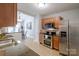 Bright kitchen with stainless steel appliances, wooden cabinets, and a breakfast bar that opens to the adjacent dining area at 2416 Hart Rd, Charlotte, NC 28214