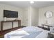 Cozy bedroom with dark wood floors, a mounted TV, and a bench with decorative cushions at 2609 Lowell Rd, Gastonia, NC 28054