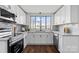 Bright kitchen features white cabinets, granite countertops, stainless steel appliances, and gray tile backsplash at 2609 Lowell Rd, Gastonia, NC 28054