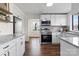 Bright kitchen features white cabinets, granite countertops, stainless steel appliances, and open shelving at 2609 Lowell Rd, Gastonia, NC 28054