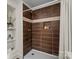 Modern shower with brown tiled walls, a built-in niche, and shelving at 2609 Lowell Rd, Gastonia, NC 28054