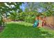 Lush backyard featuring manicured lawn, seating area with fire pit, and wooden play structure at 2841 Attaberry Dr, Charlotte, NC 28205