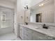 Bright bathroom featuring marble countertop, white cabinets, decorative mirrors, and window with natural light at 2841 Attaberry Dr, Charlotte, NC 28205