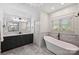 Bathroom with standalone tub, modern fixtures, marble tiling, and lots of light at 2841 Attaberry Dr, Charlotte, NC 28205