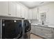 Laundry room with gray cabinetry, marble countertops, stainless steel appliances, and a window at 2841 Attaberry Dr, Charlotte, NC 28205