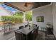 Covered outdoor patio with ceiling fan, dining table, grill, and lush backyard view at 2841 Attaberry Dr, Charlotte, NC 28205
