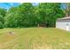 Expansive backyard showcasing a shed, outbuilding, lush lawn, and surrounding mature trees at 286 Bell Farm Rd, Statesville, NC 28625