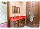 A vibrant bathroom has a red countertop and wooden cabinets, offering both style and functionality at 286 Bell Farm Rd, Statesville, NC 28625