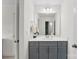 Clean bathroom with gray cabinets, ample counter space, and a large mirror with stylish lighting at 2936 Shumard Dr, Gastonia, NC 28054