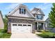 Beautiful two-story home featuring stone accents, a two-car garage, and a welcoming front porch with rocking chairs at 2936 Shumard Dr, Gastonia, NC 28054