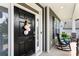 Inviting front door with elegant black finish, decorative wreath, and charming porch with rocking chairs at 2936 Shumard Dr, Gastonia, NC 28054
