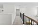 Bright hallway features neutral carpet, white walls, and beautiful wood and iron railing at 2936 Shumard Dr, Gastonia, NC 28054