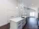 Open concept kitchen with a central island, contemporary lighting, and lots of cabinet space at 3007 West Blvd, Charlotte, NC 28208