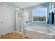 Bathroom features a separate glass shower, soaking tub, and a large window for natural light at 314 Pulaski Sw Dr, Concord, NC 28027