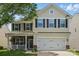 Two-story home with a front porch, two-car garage and a mix of brick, siding, and stone exterior finishes at 314 Pulaski Sw Dr, Concord, NC 28027